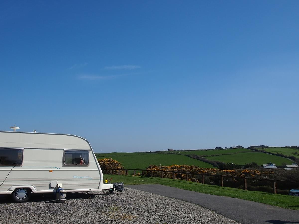 Touring caravan on a gravel hard standing with electric hook up