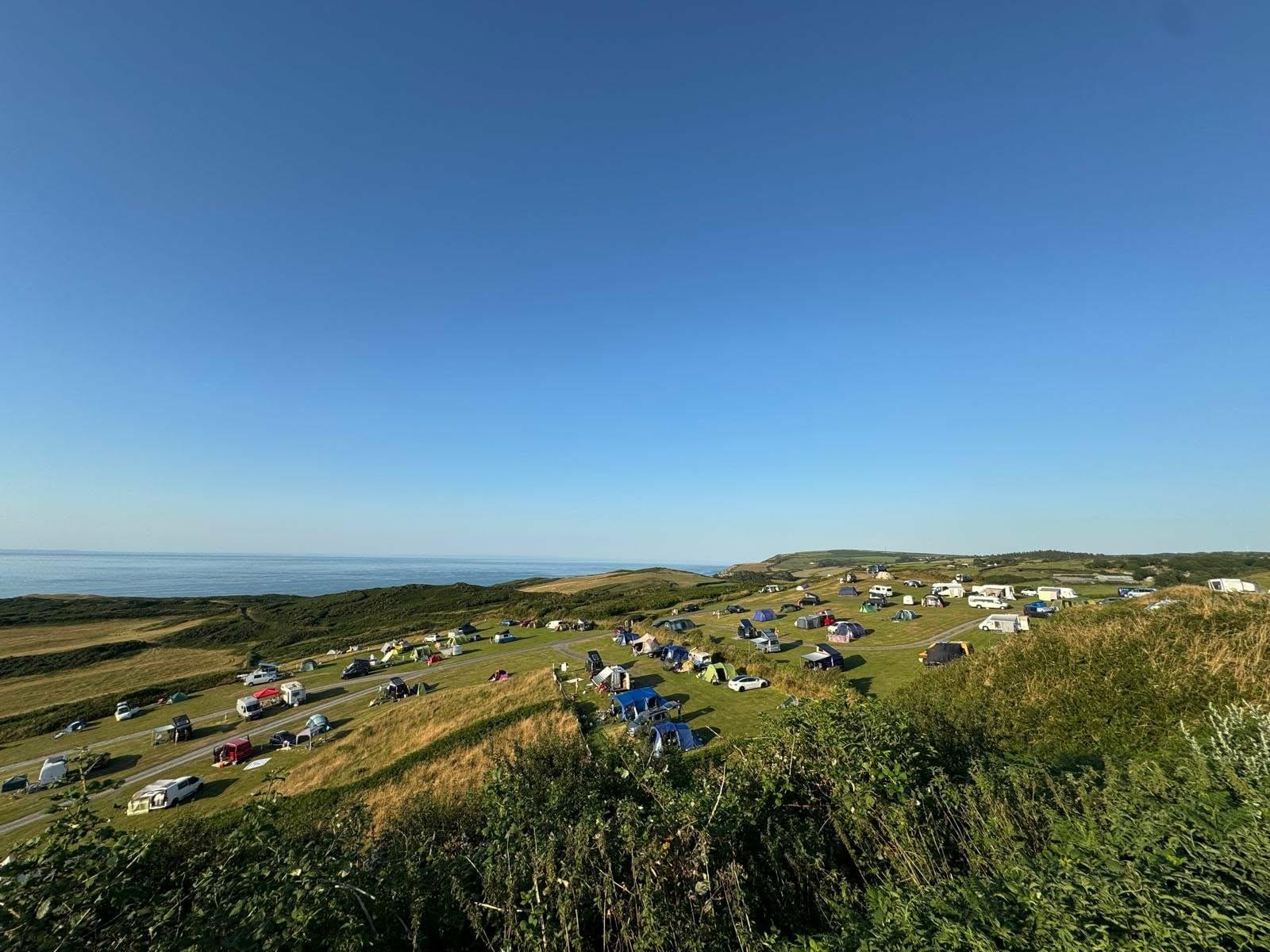 Camping field at North Morte Farm, with the sea beyond the headland